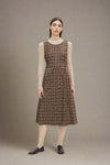 Woman wearing a brown plaid dress on a white background